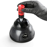 STIGMA wireless mini vortex mixer for tattoo ink, black unit, with a gloved hand inserting a red ink bottle