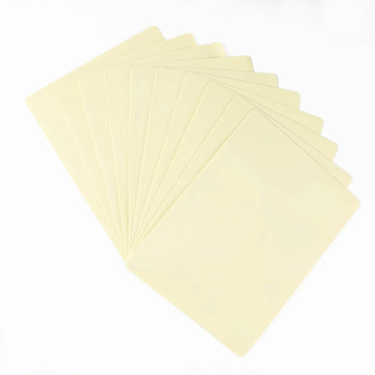 Ten rectangular, plain, untextured, light cream/beige tattoo practice skins fanned out.